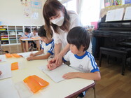 写真:書き方を教えてもらっている様子